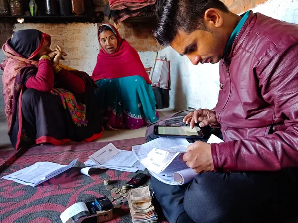 DISTRICT KATNI, INDIA - 16 HAZİRAN 2020: Hindistan küçük finans bankası personeli Mikro finans kredisi ödemesi için para topluyor, küçük grup toplantısı programı.