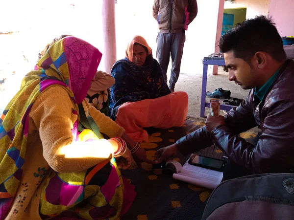 DİSTRİKT KATNI, INDIA - 16 HAZİRAN 2020: Evdeki küçük mikro finansman geri ödeme prosedürü sırasında kadın parmağı elektronik başparmak pedi makinesine dokunuyor.