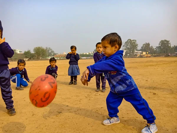 DISTRICT KATNI, INDIA - 17 HAZİRAN 2020: Hintli anaokulu erkek çocuğu voleybol maçı için voleybol topu atıyor.