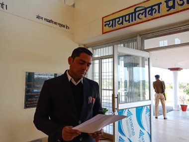 DISTRICT KATNI, INDIA - 27 HAZİRAN 2020: Yüksek mahkeme binasında dava kağıdıyla tek başına duran Hintli avukatlar derneği üyesi.