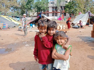 DİSTRİK KATNI, INDIA - 29 HAZİRAN 2020: 3 Hindistan köyü fakir çocuğu açık alanda yan yana duruyor.