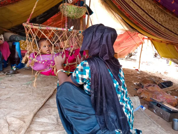 DİSTRİK KATNI, INDIA - 29 HAZİRAN 2020: Fakir bir Hint köyü annesi yeni doğan çocuğunu salıncakta sallıyor.