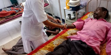 DİSTRİK KATNI, INDIA - 18 Eylül 2019: Şehir hastanesi koğuşunda erkek hastaya iğne yapan Hintli kadın doktor.