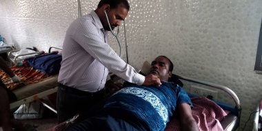 DISTRICT KATNI, INDIA - 28 Eylül 2019: Hintli bir MBBS doktoru erkek hasta nabız hızını test ediyor.