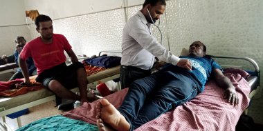 DISTRICT KATNI, INDIA - 28 Eylül 2019: Hintli bir erkek doktor hasta kalp atış hızını test ediyor.