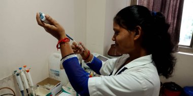 DISTRICT KATNI, INDIA - 28 Eylül 2019: Şehir hastanesi koğuşundaki patoloji laboratuvarında kan testi yapan Hintli bir kadın laboratuvar teknisyeni.