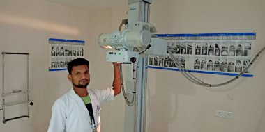 DISTRICT KATNI, INDIA - 28 Eylül 2019: Hintli bir erkek laboratuvar teknisyeni kemik kırığı tıbbi koğuşunda röntgen cihazı panelini düzeltiyor.