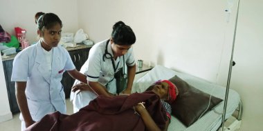 DİSTRİK KATNI, INDIA - 28 Eylül 2019: Hintli bir kadın doktor şehir hastanesindeki yaşlı kadın hastayı kontrol ediyor.