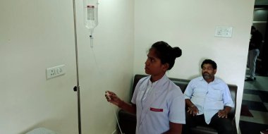 DISTRICT KATNI, INDIA - 28 Eylül 2019: Hintli bir bayan doktor şehir hastanesindeki sıvı şişe panelini düzeltiyor.