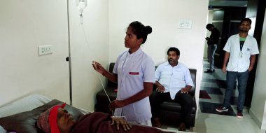 DISTRICT KATNI, INDIA - 28 Eylül 2019: Şehir hastanesinde glikoz likidite hızını kontrol eden Hintli bir bayan hemşire.