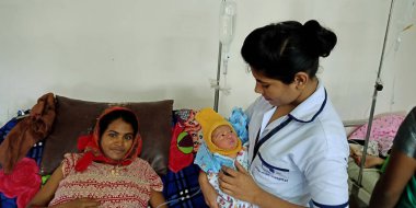 DİSTRİK KATNI, INDIA - 28 Eylül 2019: Hintli bir bayan doktor, devlet hastanesinde kucağında annesinin kucağında yeni doğan bir bebeği taşıdı.