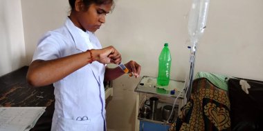 DISTRICT KATNI, INDIA - 28 Eylül 2019: Asyalı bir kadın doktor, devlet hastanesinde tıptan iğneyi dolduruyor.