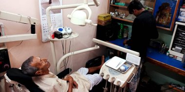 DISTRICT KATNI, INDIA - 29 Eylül 2019: Şehir hastanesindeki diş sağlığı kliniğinde oral enfeksiyon testi için dişçi koltuğunda yatan Hintli bir köy hastası.