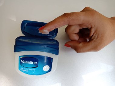 DİSTRİK KATNI, Hindistan - 30 Aralık 2019: Vazelin nemlendirici krem ve kadın eli izole edilmiş.