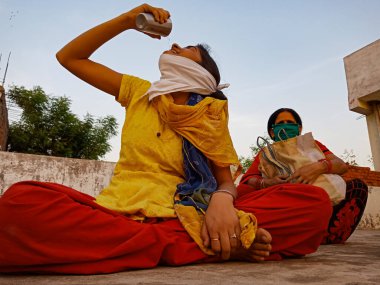 DISTRICT KATNI, INDIA - 21 Mayıs 2020: Koronavirüs koruması için maske takan Hindistan köylü fakir bir kız.