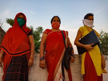 DISTRICT KATNI, INDIA - 21 Mayıs 2020: Koronavirüs koruması için maske takan bir Hint köyü yoksul kadın grubu.