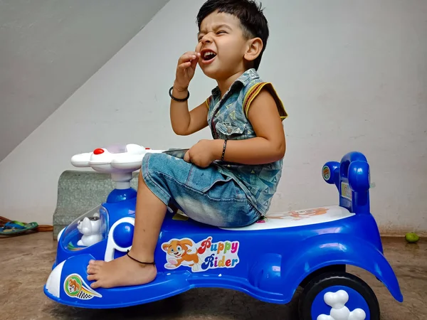 DİSTRİK KATNI, Hindistan - 21 Mayıs 2020: Oyuncak bisiklette oturan Hintli şirin bir çocuk.