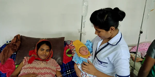 DİSTRİK KATNI, INDIA - 28 Eylül 2019: Hintli bir bayan doktor, devlet hastanesinde kucağında annesinin kucağında yeni doğan bir bebeği taşıdı.