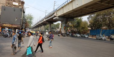 CITY DELHI, INDIA - 25 HAZİRAN 2020: Hint insan grupları metro istasyonu yakınlarındaki yoldan geçiyorlar.
