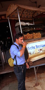 KITY KATNI, INDIA - 21 AĞUSTOS 2019: Restoranda cam üzerinde çay içen Asyalı akıllı çocuk.