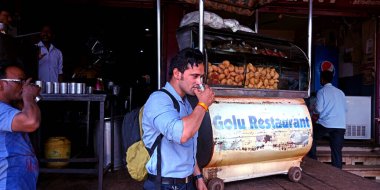 KITY KATNI, INDIA - 21 AĞUSTOS 2019: Restoranda cam üzerinde çay içen Asyalı profesyonel bir çocuk.