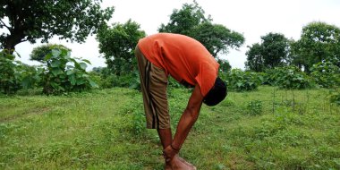 DİSTRİK KATNI, INDIA - 05 Ağustos 2019: Yeşil yatay orman arka planı üzerinde egzersiz yapan bir Hint köylüsü.