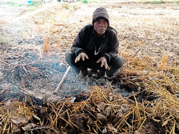DİSTRİK KATNI, Hindistan - 13 Aralık 2019: Kış mevsiminde ateşin etrafında oturan yaşlı bir Hint köyü.