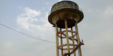 Gökyüzü arka planında çimento maddesiyle izole edilmiş su tankı.