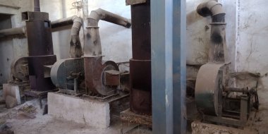 Paslı arka plana maruz bırakılmış eski bir pirinç değirmeni makine tedarik aracı.