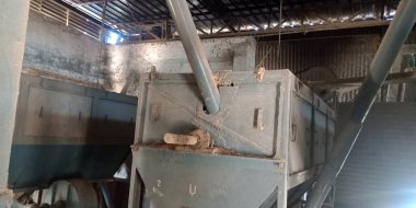 Paslı arka plana maruz bırakılmış eski bir pirinç değirmeni makine boru tedarik aracı.