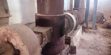 Paslı arka plana maruz bırakılmış eski bir pirinç değirmeni makinesi..