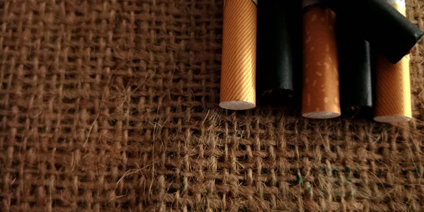 棕色和黑色香烟在棕色背包垫的背景上 香烟的包装 香烟的特写 — 图库照片