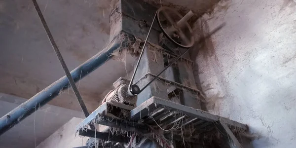 Paslı arka plana maruz kalmış eski bir pirinç değirmeni makine kemeri..