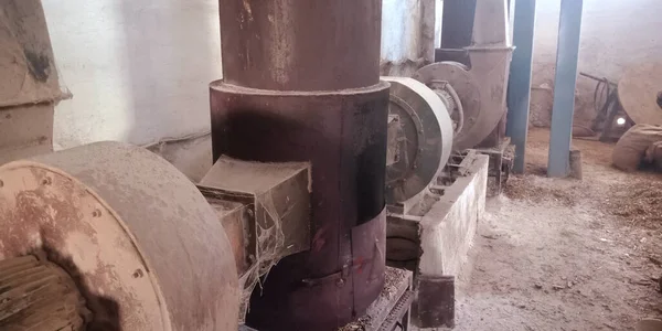 Paslı arka plana maruz bırakılmış eski bir pirinç değirmeni makinesi..