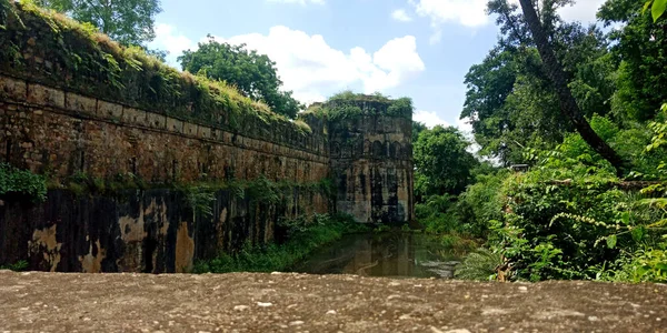 India tourist attraction kingdom architecture, water wall Fort at green forest background ancient style.