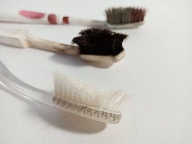 Üç kullanılmış diş fırçası pazarlama ve markalaşma amaçlı arka planda izole edilmiş..