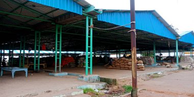 DISTRICT KATNI, INDIA - 22 Temmuz 2019: Tarım ürünleri pazar deposu Yol kenarı arka planında bina manzarası.