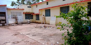 DISTRICT KATNI, INDIA - 29 Temmuz 2019: Hükümet binasının arka planına işeyen Hintliler.