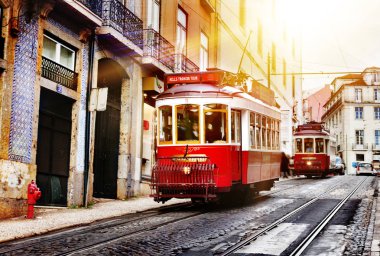 Lizbon, Portekiz. Gün batımında Lizbon'da bir sokakta kırmızı tramvay. Sokak fotoğrafçılığı. Tatiller ve turistik yerler.