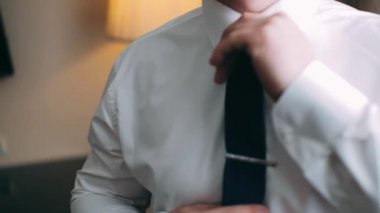 Adam kravatını düzeltiyor. Beyaz gömlekli bir adam siyah kravatı düzeltiyor.