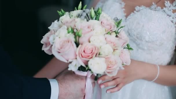 新郎は花嫁に花束をあげます 女性の手は優しく白いバラの花束を持っています — ストック動画