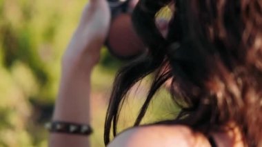 Dişi bacaklar yakın plan. Elle okşayan bacaklar. Doğadaki kız çimenlerde oturur.