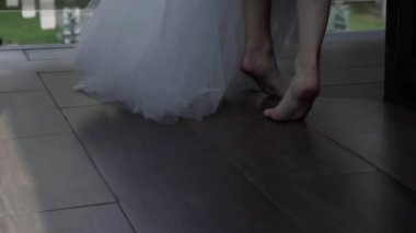 Kadınların çıplak ayakları terasta yürüyor.