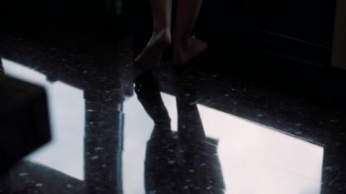 Kadınların çıplak ayakları terasta yürüyor.