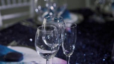 Mavi bir masa örtüsünün üzerinde şeffaf bardaklar duruyor.