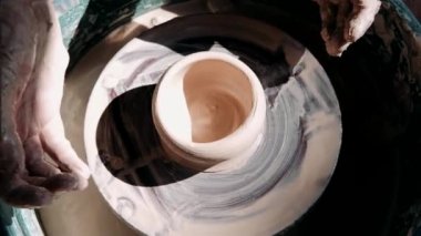 Zanaatkar çömlekçi çömlekçiliği için malzeme hazırlar. Güçlü erkek eller, modellik ve heykel için ıslak çamuru sıkıştırıyor. Yakın planda çalış. Çömlekçilik, el yapımı ve yaratıcı beceriler.