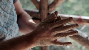 Zanaatkar çömlekçi çömlekçiliği için malzeme hazırlar. Güçlü erkek eller, modellik ve heykel için ıslak çamuru sıkıştırıyor. Yakın planda çalış. Çömlekçilik, el yapımı ve yaratıcı beceriler.