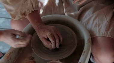 Zanaatkar çömlekçi çömlekçiliği için malzeme hazırlar. Güçlü erkek eller, modellik ve heykel için ıslak çamuru sıkıştırıyor. Yakın planda çalış. Çömlekçilik, el yapımı ve yaratıcı beceriler.