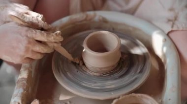 Zanaatkar çömlekçi çömlekçiliği için malzeme hazırlar. Güçlü erkek eller, modellik ve heykel için ıslak çamuru sıkıştırıyor. Yakın planda çalış. Çömlekçilik, el yapımı ve yaratıcı beceriler.