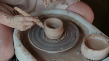 Zanaatkar çömlekçi çömlekçiliği için malzeme hazırlar. Güçlü erkek eller, modellik ve heykel için ıslak çamuru sıkıştırıyor. Yakın planda çalış. Çömlekçilik, el yapımı ve yaratıcı beceriler.